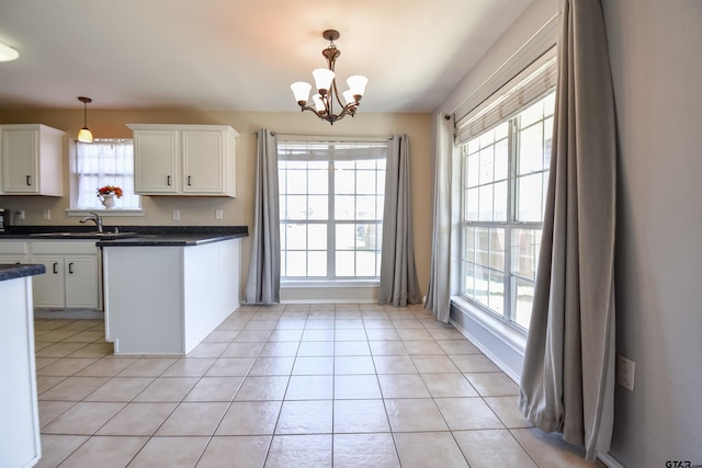 kitchen with light tile patterned floors, decorative light fixtures, and white cabinets