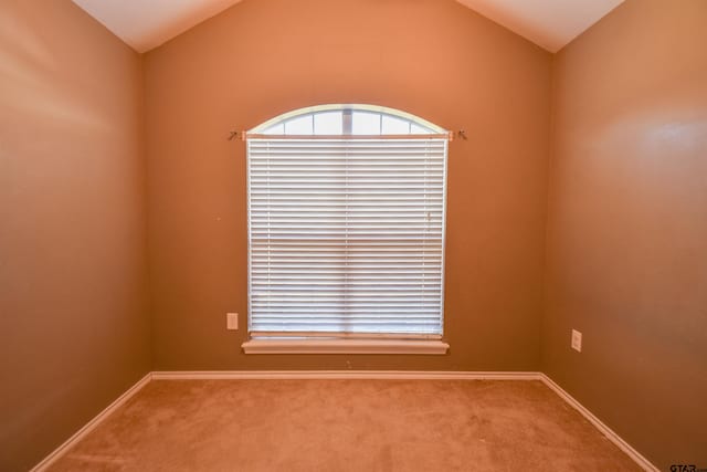 unfurnished room featuring lofted ceiling and carpet floors