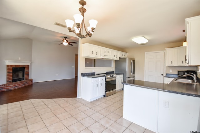 kitchen featuring stainless steel appliances, kitchen peninsula, sink, and white cabinets