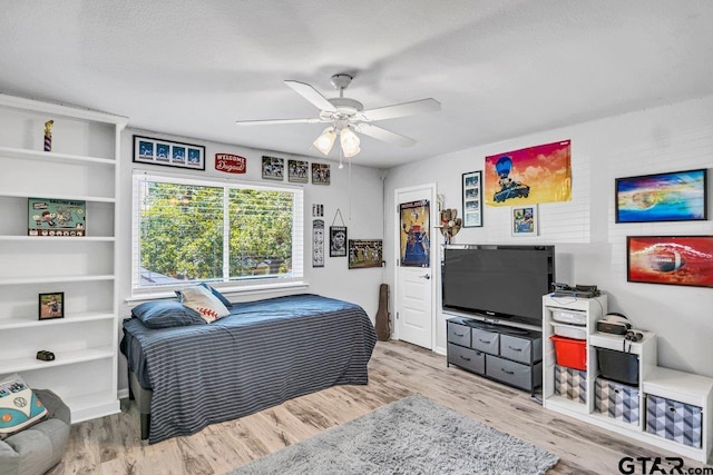 bedroom with a textured ceiling, light hardwood / wood-style floors, and ceiling fan