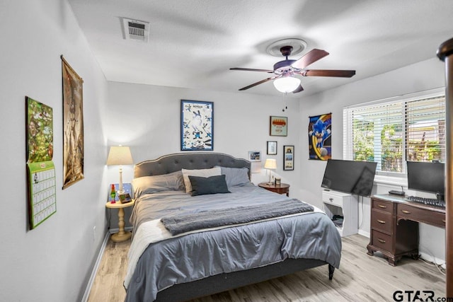 bedroom with ceiling fan, light wood-type flooring, and a textured ceiling