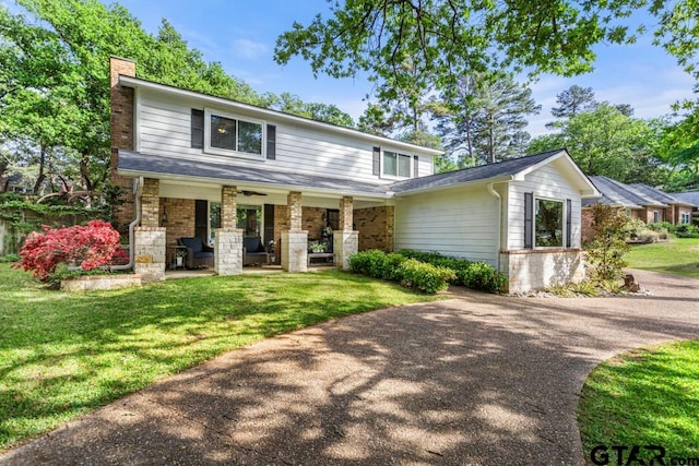 view of front of home featuring covered porch and a front lawn