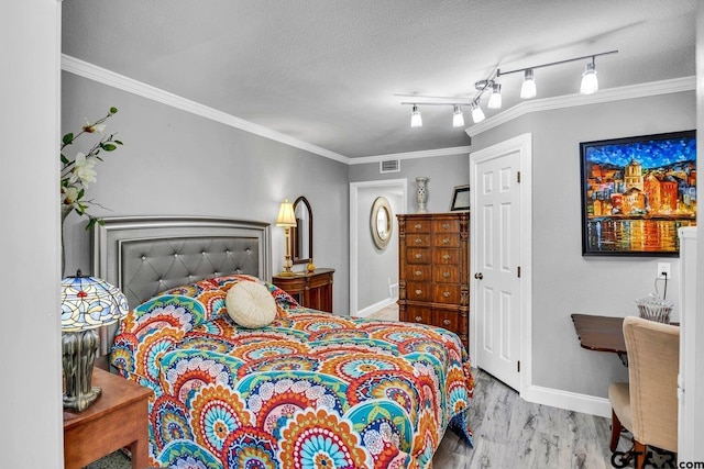 bedroom with a textured ceiling, crown molding, and light hardwood / wood-style flooring