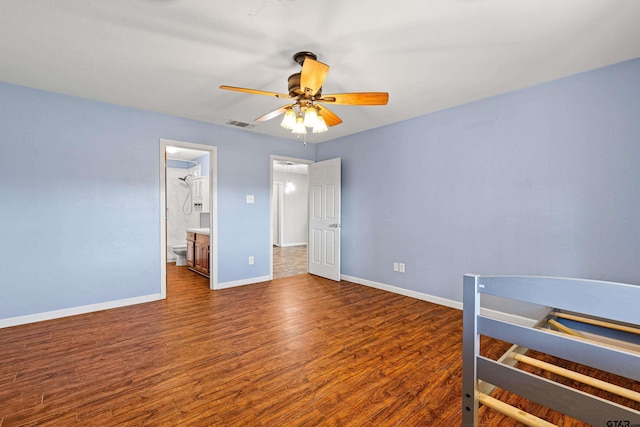 bedroom featuring ceiling fan, ensuite bath, and dark wood-type flooring