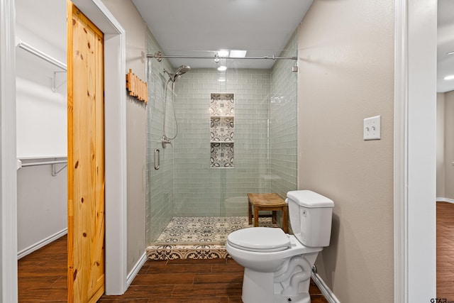 bathroom featuring toilet, walk in shower, and hardwood / wood-style floors