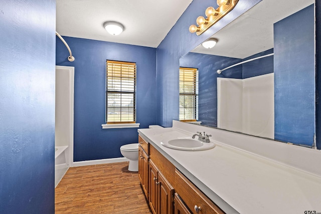 full bathroom featuring toilet, vanity, hardwood / wood-style floors, and shower / tub combination