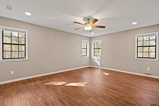 spare room with hardwood / wood-style flooring, ceiling fan, and a healthy amount of sunlight