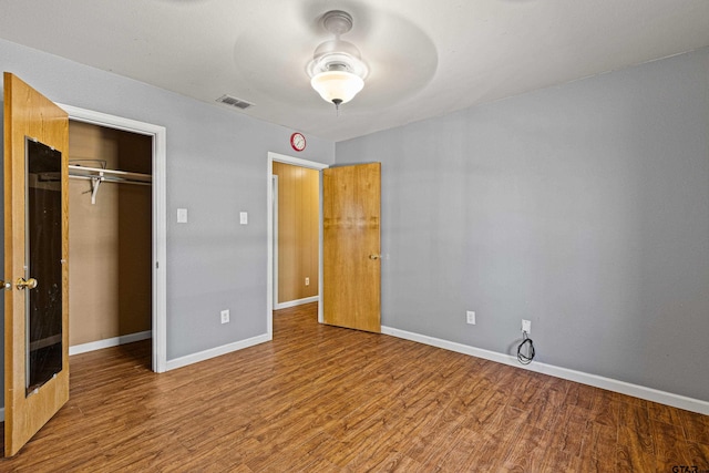 unfurnished bedroom with wood-type flooring and a closet