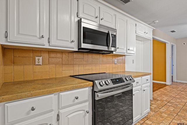 kitchen featuring white cabinetry, appliances with stainless steel finishes, and tasteful backsplash