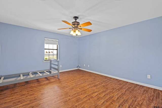 spare room with ceiling fan and wood-type flooring