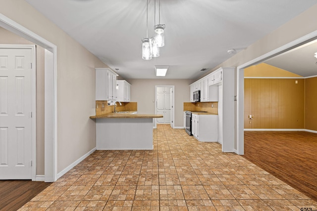 kitchen featuring white cabinetry, kitchen peninsula, appliances with stainless steel finishes, and sink