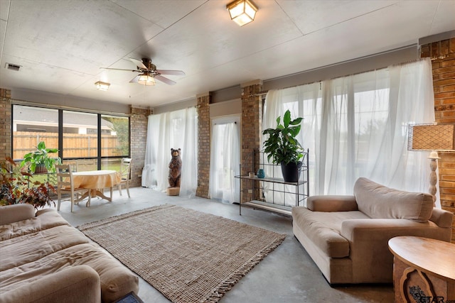 living room with ceiling fan and concrete flooring