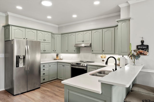 kitchen with a kitchen bar, stainless steel appliances, sink, backsplash, and kitchen peninsula