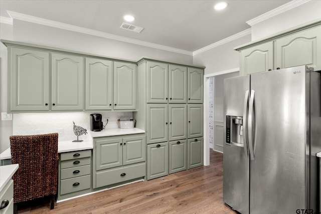 kitchen with dark hardwood / wood-style floors, stainless steel fridge with ice dispenser, crown molding, and green cabinets