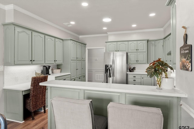 kitchen with kitchen peninsula, stainless steel refrigerator with ice dispenser, crown molding, light hardwood / wood-style flooring, and a kitchen breakfast bar