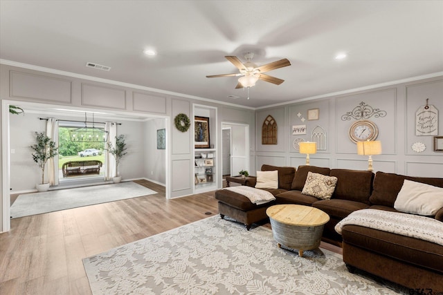 living room with ceiling fan, crown molding, and light hardwood / wood-style floors