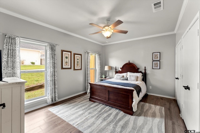 bedroom with hardwood / wood-style flooring, crown molding, and ceiling fan