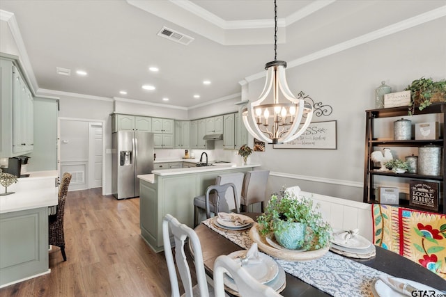 dining room with an inviting chandelier, sink, crown molding, and light hardwood / wood-style flooring