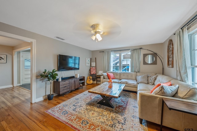 living room with wood-type flooring and ceiling fan