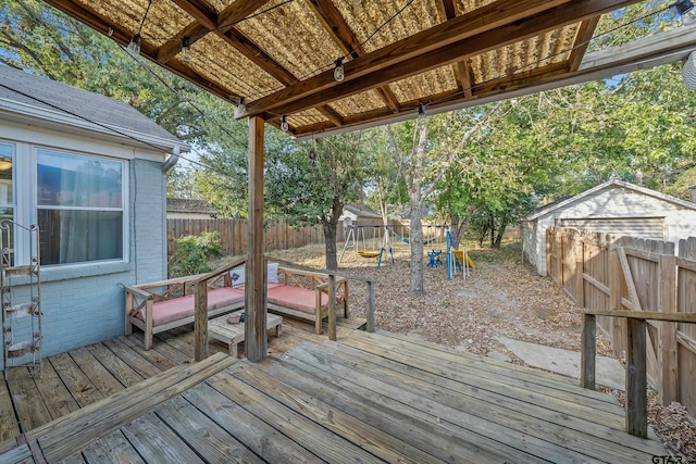 deck with a playground and a shed