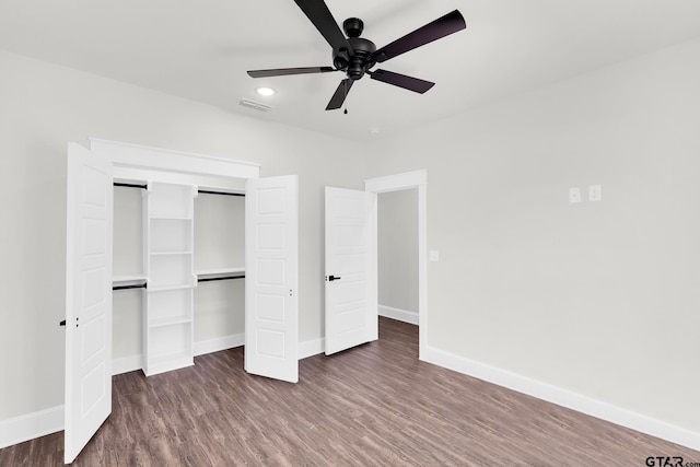 unfurnished bedroom with dark wood-type flooring, ceiling fan, and a closet