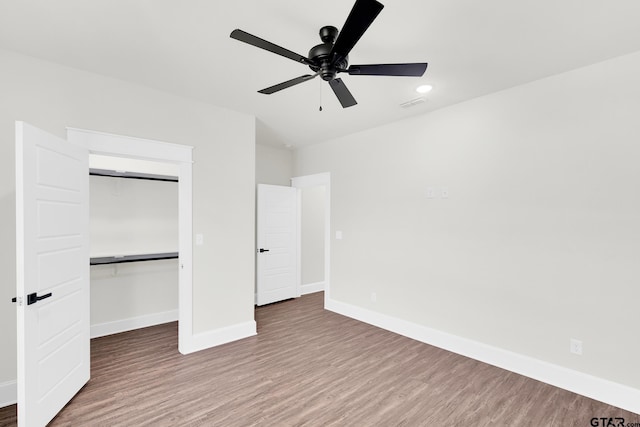 unfurnished bedroom with ceiling fan, wood-type flooring, and a closet