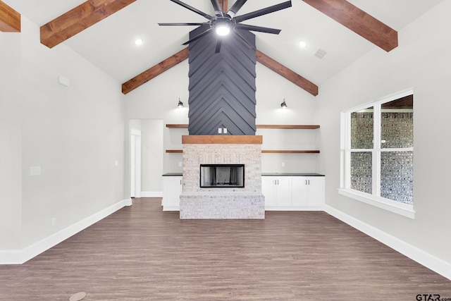 unfurnished living room featuring ceiling fan, beam ceiling, high vaulted ceiling, dark hardwood / wood-style flooring, and a brick fireplace