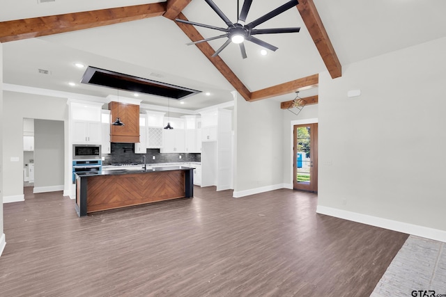 kitchen with a kitchen island with sink, hanging light fixtures, white cabinetry, stainless steel appliances, and lofted ceiling with beams