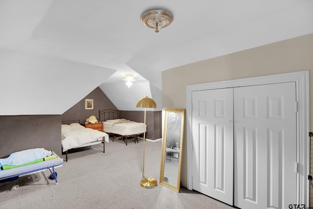 bedroom with carpet flooring, a closet, and lofted ceiling