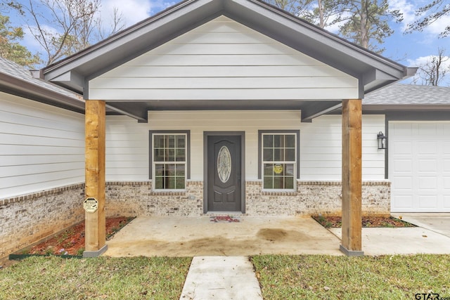 doorway to property featuring covered porch and a garage