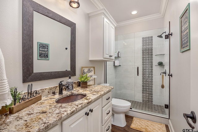 bathroom featuring toilet, wood-type flooring, crown molding, vanity, and a shower with shower door