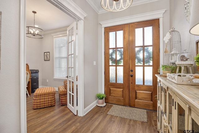 doorway with ornamental molding, french doors, hardwood / wood-style floors, and a chandelier