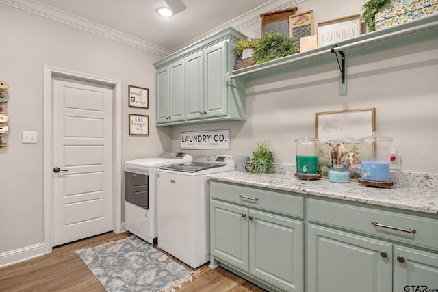 laundry area featuring washing machine and dryer, cabinets, crown molding, and light hardwood / wood-style flooring