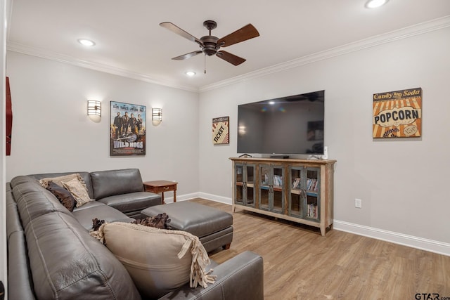 living room featuring ornamental molding, ceiling fan, and light wood-type flooring