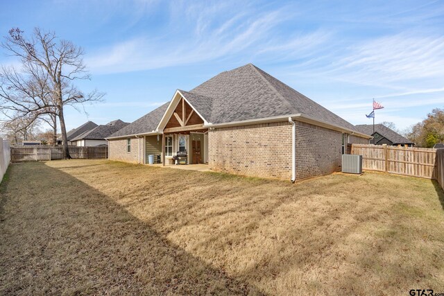 rear view of property with a lawn, cooling unit, and a patio area