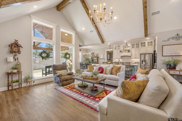 living room featuring wood-type flooring, a notable chandelier, high vaulted ceiling, beam ceiling, and sink