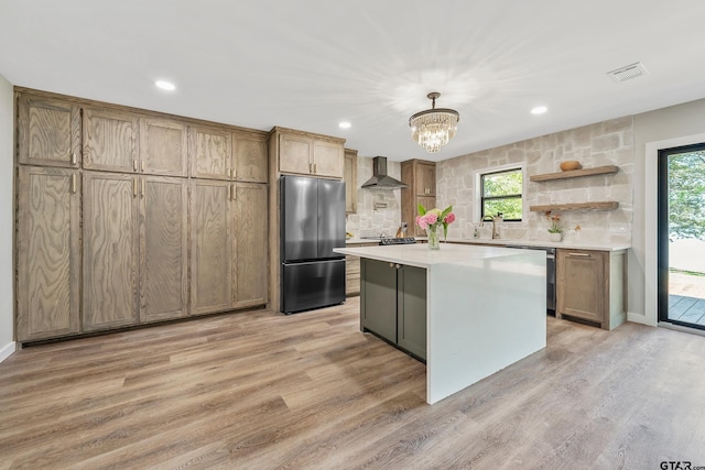 kitchen featuring a kitchen island, stainless steel refrigerator, hanging light fixtures, and a healthy amount of sunlight