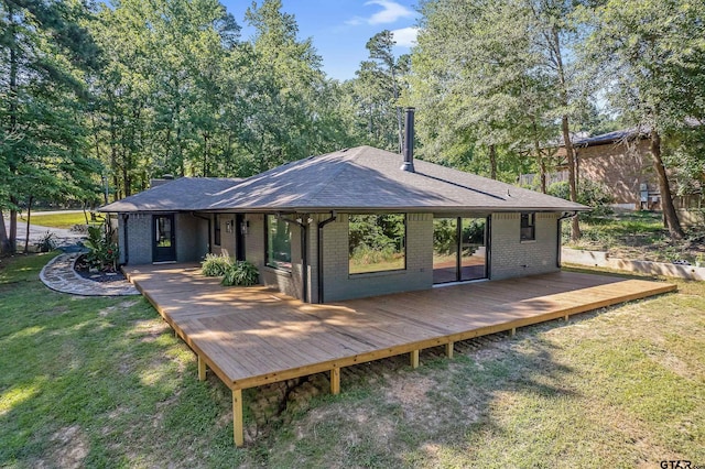 rear view of house with a yard and a wooden deck