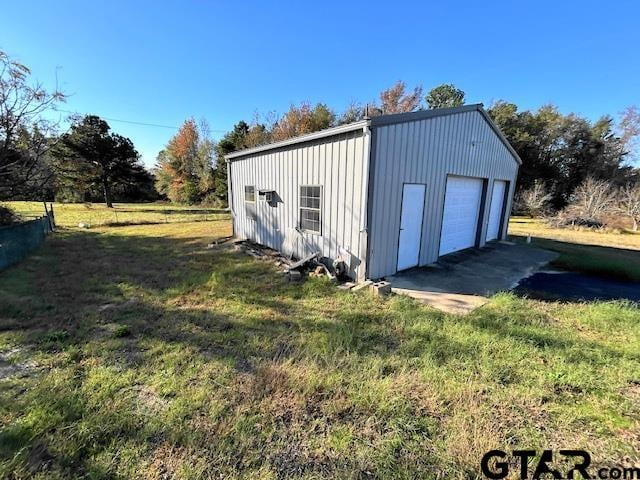 view of outbuilding featuring a lawn and a garage