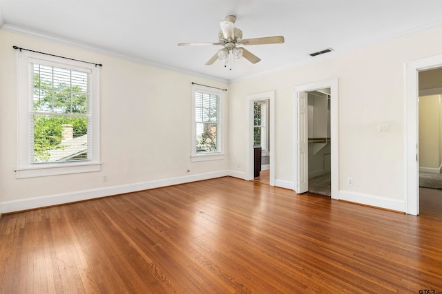 unfurnished bedroom with hardwood / wood-style flooring, ceiling fan, a spacious closet, crown molding, and a closet