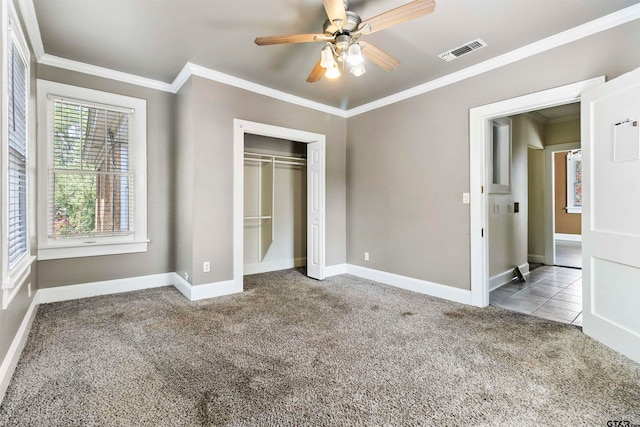 unfurnished bedroom featuring ornamental molding, light carpet, ceiling fan, and a closet