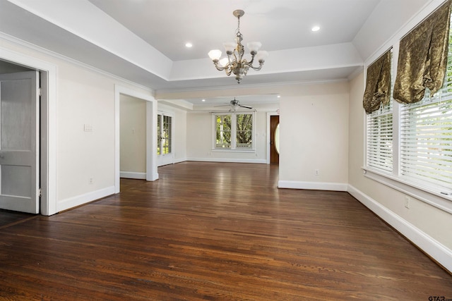 unfurnished living room with dark wood-type flooring, a raised ceiling, and ceiling fan with notable chandelier