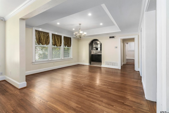 unfurnished living room with dark hardwood / wood-style floors, a chandelier, and crown molding