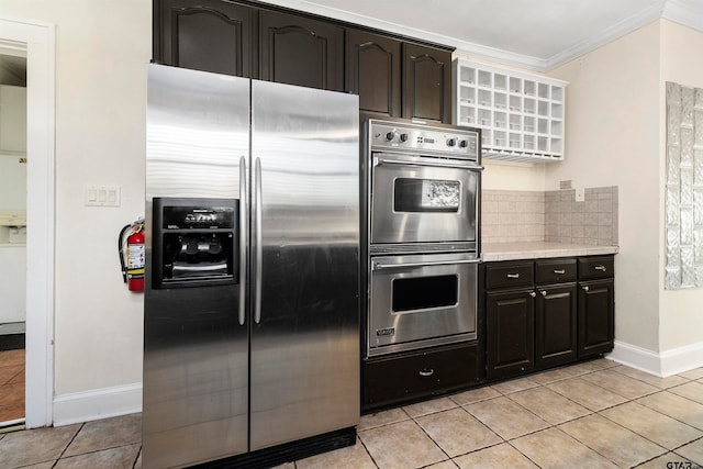 kitchen featuring light tile patterned floors, tasteful backsplash, crown molding, dark brown cabinets, and appliances with stainless steel finishes