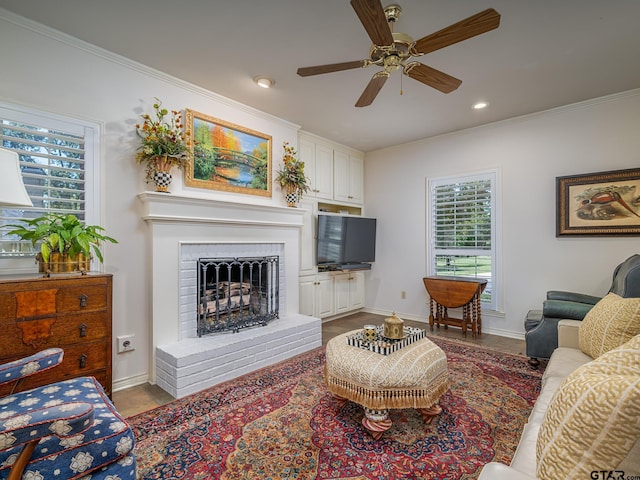 living room featuring a brick fireplace, ornamental molding, and ceiling fan