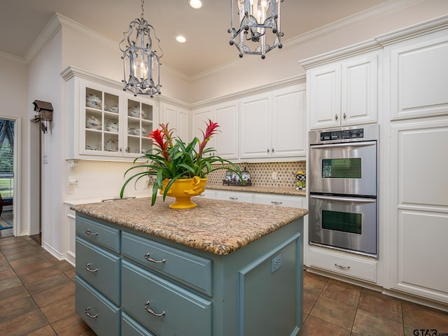 kitchen with double oven, white cabinetry, pendant lighting, and a center island