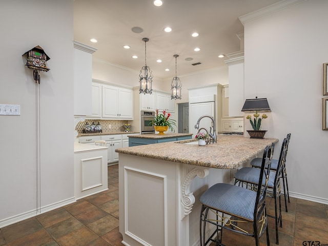 kitchen featuring sink, decorative light fixtures, stainless steel oven, white cabinets, and a kitchen bar