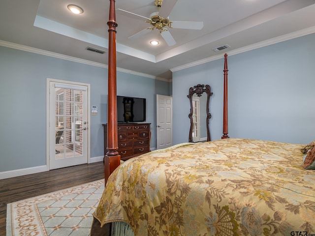 bedroom featuring ceiling fan, a tray ceiling, ornamental molding, and dark hardwood / wood-style floors