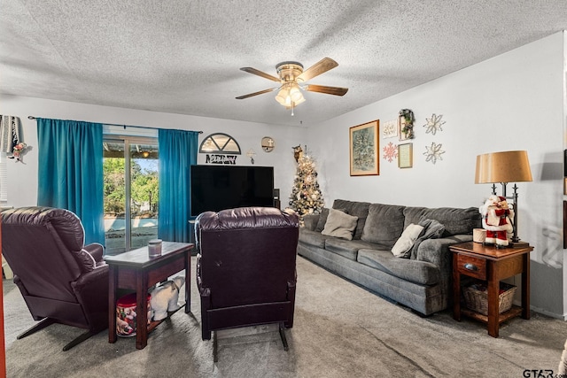 carpeted living room featuring ceiling fan and a textured ceiling