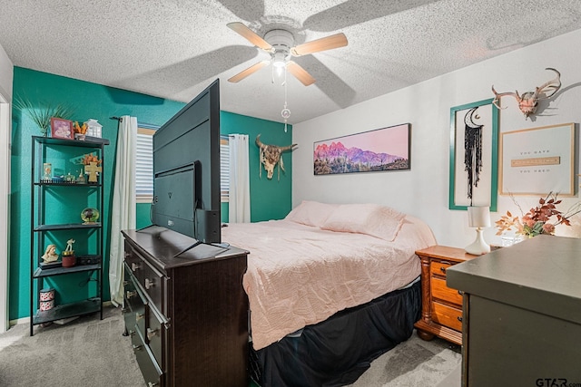 bedroom with ceiling fan, light colored carpet, and a textured ceiling